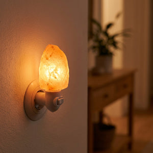 Lampe de sel de l'Himalaya allumée dans un couloir cosy près d'une console en bois