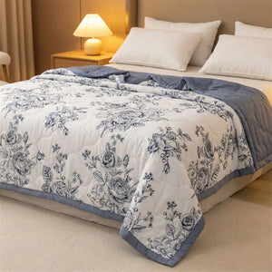 Couette d'été à roses bleutées sur un lit avec lampe de chevet chaleureuse le soir