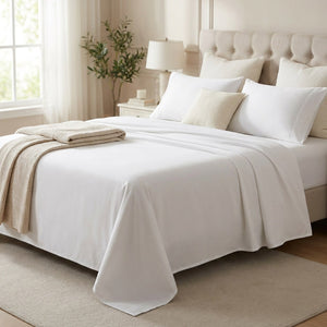 Drap plat blanc sur un lit avec jeté replié dans une chambre élégante
