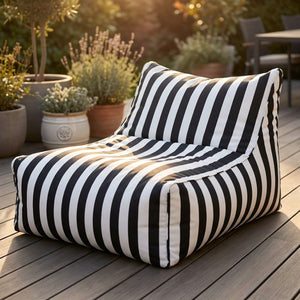 Pouf géant à rayures installé sur une terrasse en bois avec des plantes