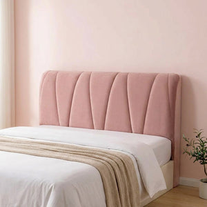 Housse de tête de lit rose capitonnée dans une chambre pastel épurée avec une plante