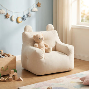 Fauteuil enfant écru dans une chambre d'enfant avec peluche et jouets en bois
