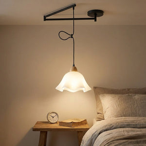 Lampe suspendue près d'une table de chevet dans une chambre cosy