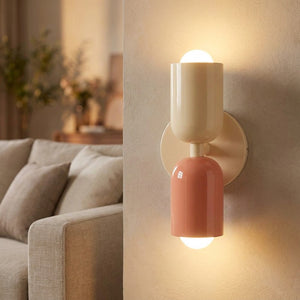 Applique murale LED double tête allumée près d'un canapé dans un salon chaleureux