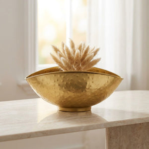 Coupe décorative dorée garnie de pampas sur une console en marbre près d une fenêtre