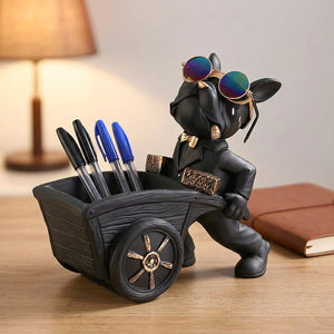 Statue de bouledogue noir tenant des stylos dans sa brouette sur un bureau