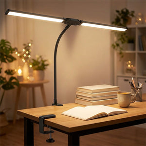 Lampe de bureau double tête noire diffusant une lumière chaude sur un carnet ouvert le soir