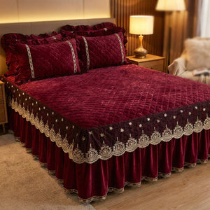 Couvre-lit matelassé grenat sur un lit avec table de chevet et lampe chaleureuse