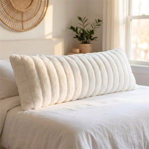 Traversin en peluche blanche dans une chambre lumineuse au style scandinave