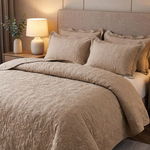 Couvre-lit matelassé beige sur un lit avec lampe de chevet à la lumière chaude