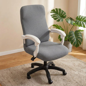Housse de chaise de bureau grise en maille gaufrée dans un bureau cosy avec plante verte