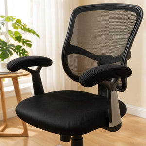 Fauteuil de bureau avec ses housses d'accoudoir noires dans un coin bureau lumineux et chaleureux