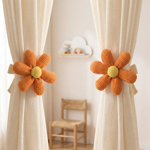 Deux attaches rideau fleur orange retenant des rideaux clairs dans une chambre d enfant avec etagere nuage
