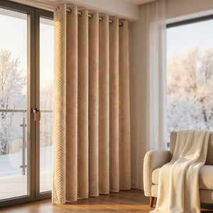 Rideau beige chevron près d'une porte de balcon avec fauteuil et plaid