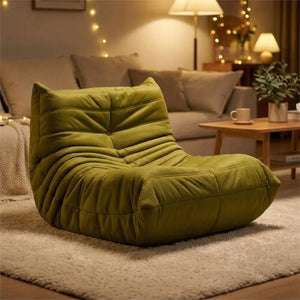 Pouf géant canapé de sol vert olive dans un salon cosy éclairé en soirée