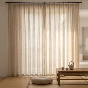 Voilage aspect lin naturel dans un coin zen japandi avec table basse et coussin de sol