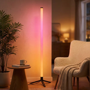 Lampadaire LED RGB près d'un fauteuil avec une lumière rose chaleureuse