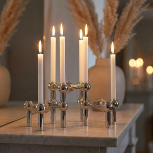 Chandeliers modulaires argentés sur une étagère en marbre avec des herbes de la pampa