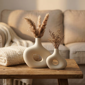 Deux vases en céramique donut sur une table basse avec un plaid et un canapé