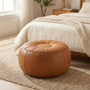 Pouf de rangement caramel au pied d'un lit dans une chambre chaleureuse