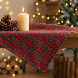 Détail du tissu tissé d'une nappe de Noël à carreaux tartan près d'une bougie