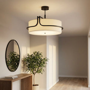 Lustre en tissu crème allumé dans une entrée avec miroir rond et plante