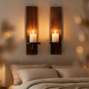 Deux bougeoirs muraux en bois au-dessus d'une tête de lit en lin dans une chambre cosy