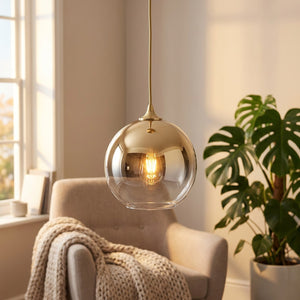 Suspension boule de verre dorée dans un coin salon chaleureux avec fauteuil et plante