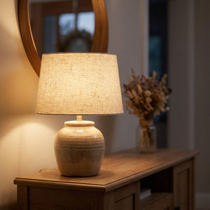 Abat-jour en lin naturel beige sur une lampe de chevet dans une entrée chaleureuse