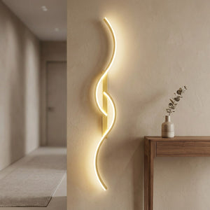 Applique murale LED dorée dans une entrée moderne près d'une console en bois