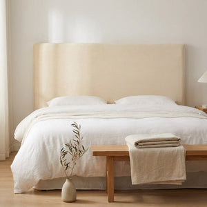 Housse de tête de lit en velours beige dans une chambre minimaliste épurée