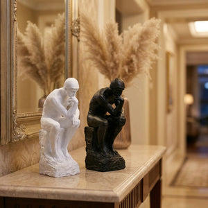 Statue Le Penseur de Rodin blanche et noire sur une console d'entrée en marbre