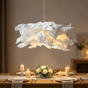 Lustre nuage en papier allumé au-dessus d'une table à manger dressée aux chandelles