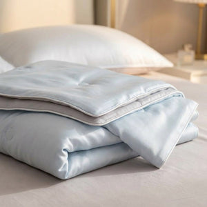 Détail de la surface soyeuse et du passepoil satiné de la couette bleue en soie glacée