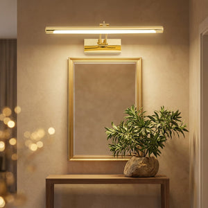 Applique murale miroir LED dorée allumée au-dessus d'un miroir encadré dans une entrée chaleureuse