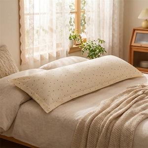 Gros plan sur le motif pois de la taie d'oreiller longue sur un lit