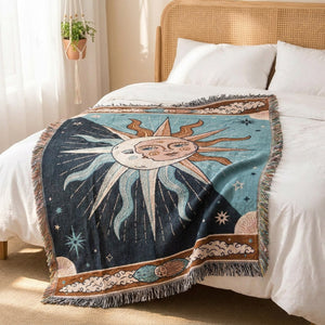 Tapisserie plaid soleil et lune drapée au pied d'un lit avec tête de lit en rotin