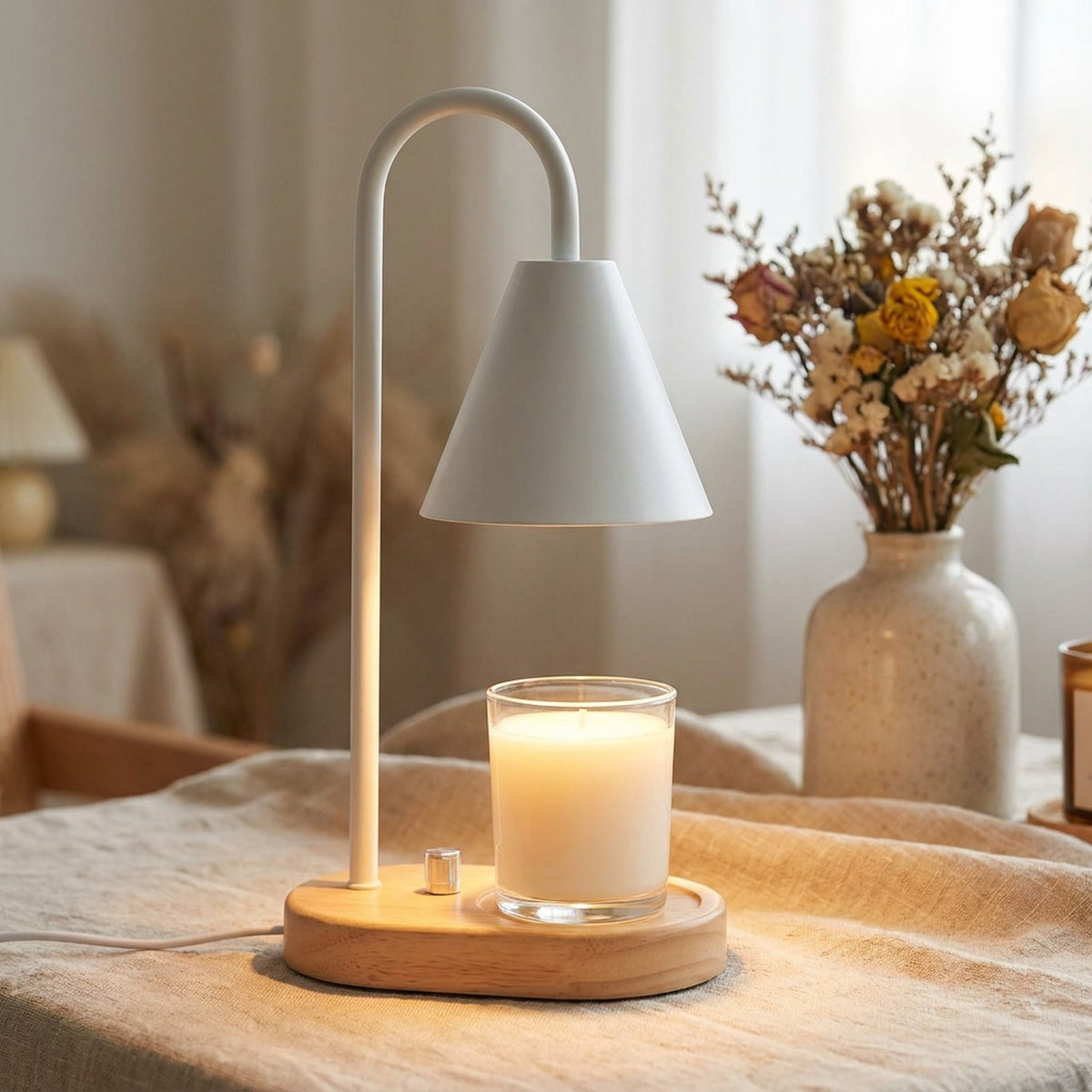 Chauffe-bougie électrique blanc sur nappe en lin avec fleurs séchées