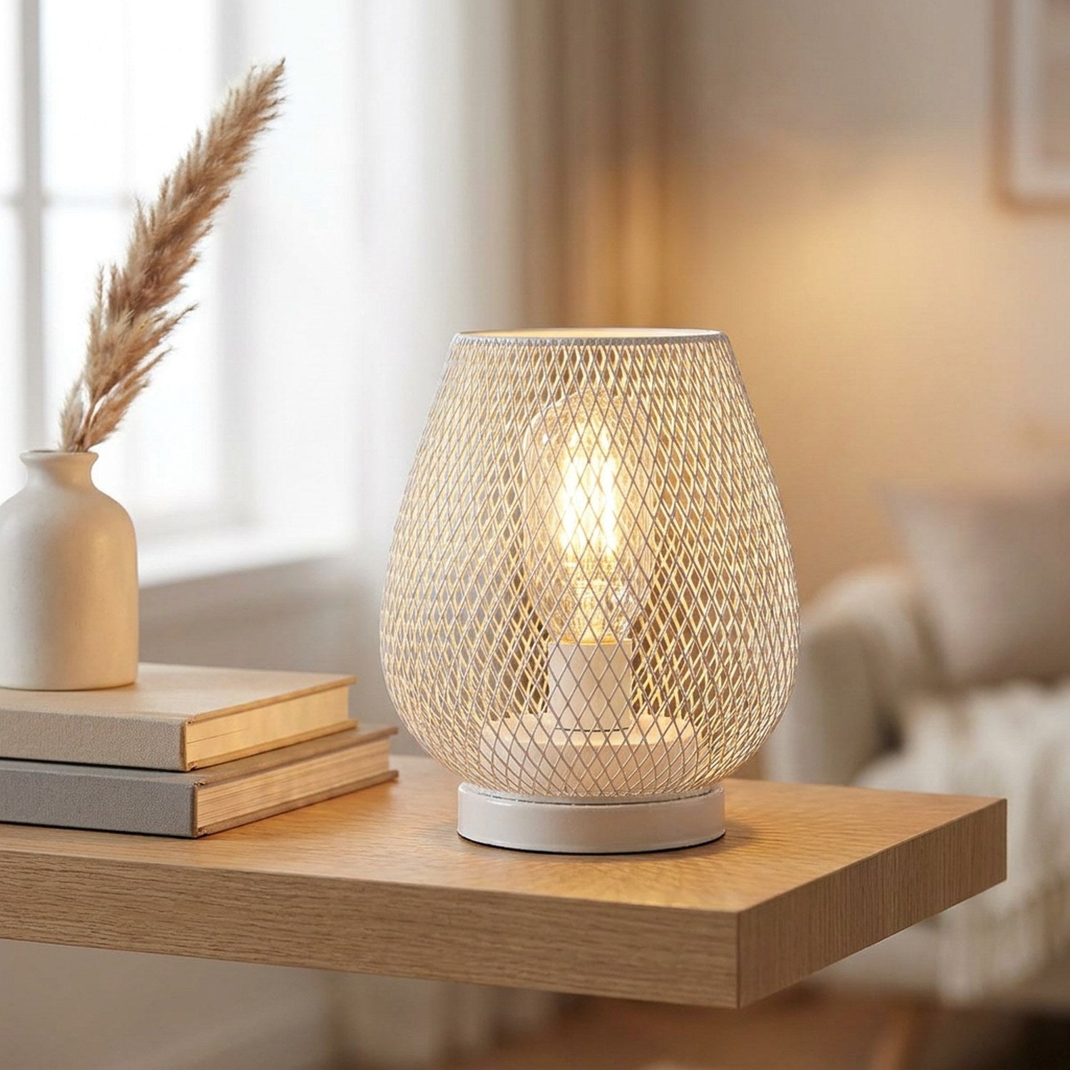 Lampe industrielle cage grillagée sur une étagère avec livres et vase en bois