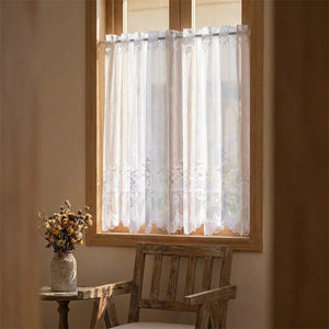 Rideau brise vue en dentelle dans une chambre cosy avec fleurs sechees