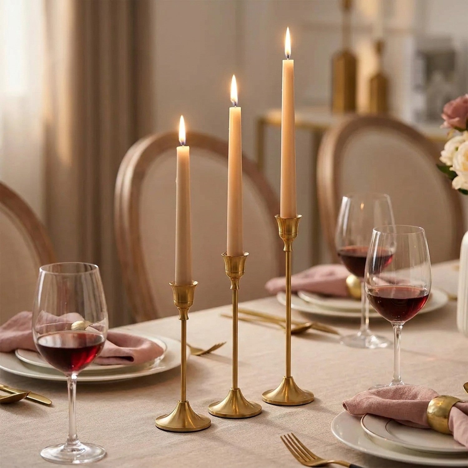 Table de salle à manger dressée avec bougeoirs vintage en métal doré et bougies ivoire allumées
