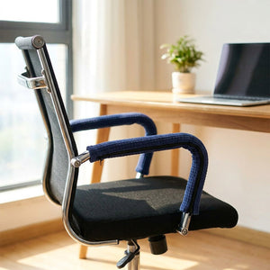 Chaise de bureau avec housses d'accoudoir bleu marine près d'une fenêtre lumineuse