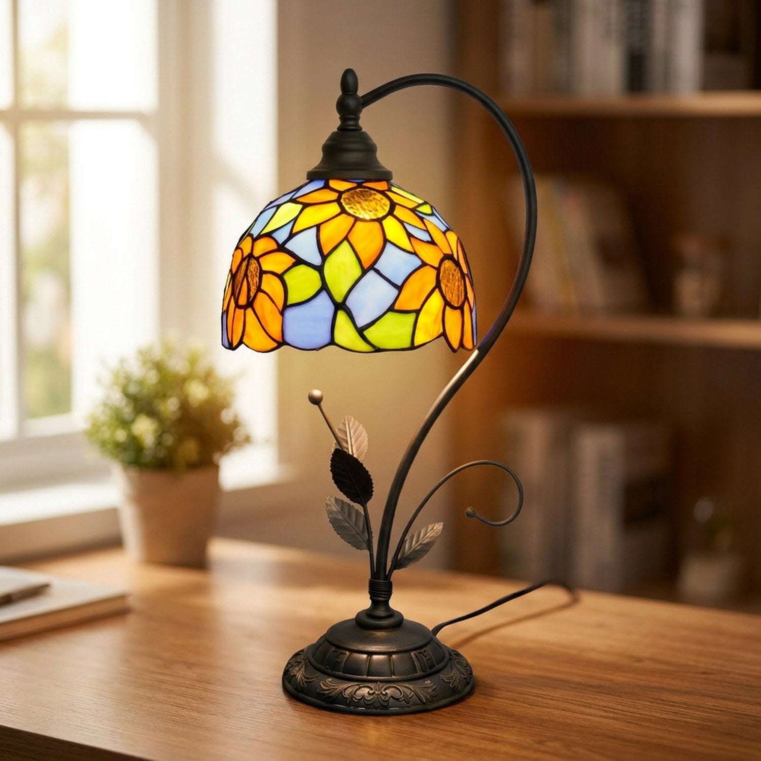 Lampe de table style Tiffany allumée sur un bureau en bois près d'une fenêtre
