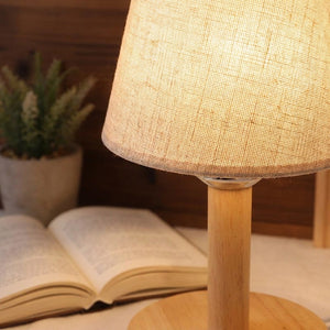 Abat-jour lin posé sur lampe de chevet bois dans chambre cosy ambiance soir