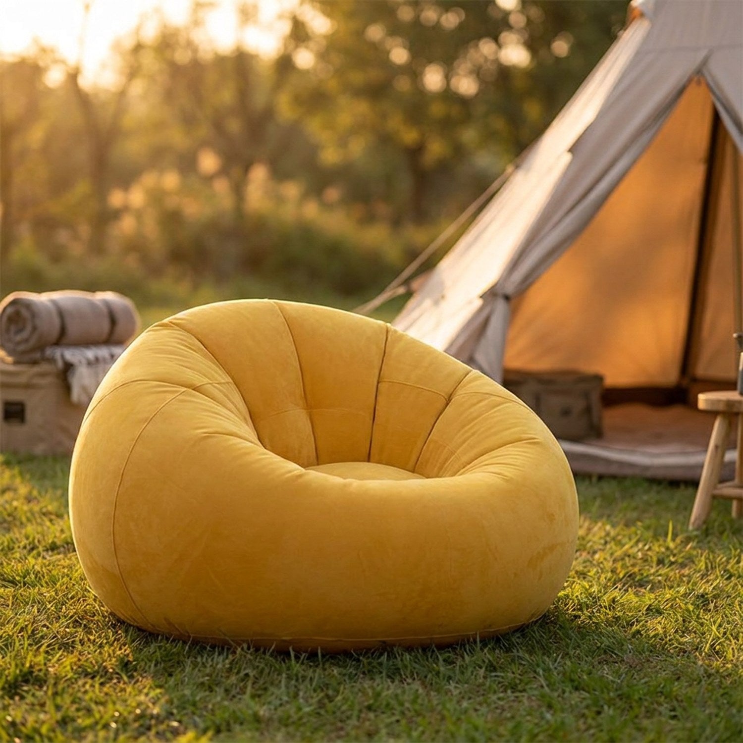 Pouf gonflable jaune installé sur l'herbe près d'une tente de camping