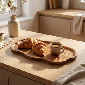 Plateau en bois organique avec croissants et café dans une cuisine scandinave lumineuse