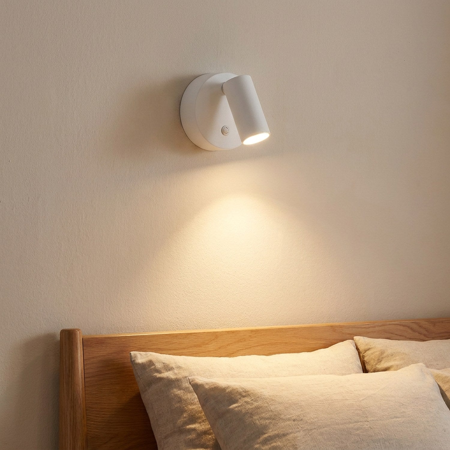 Applique murale LED blanche fixée au-dessus d'une tête de lit en bois
