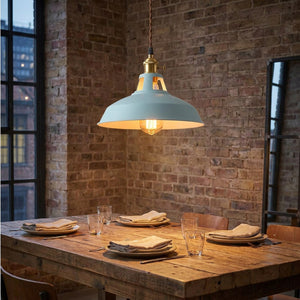 Suspension rétro industrielle allumée au-dessus d'une table en bois dans une cuisine vintage
