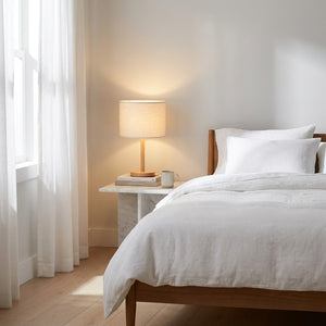 Abat-jour tambour en lin sur lampe de chevet dans une chambre sereine