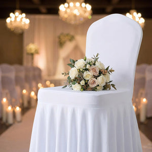 Bouquet de roses posé sur une chaise habillée d'une housse blanche à jupe plissée